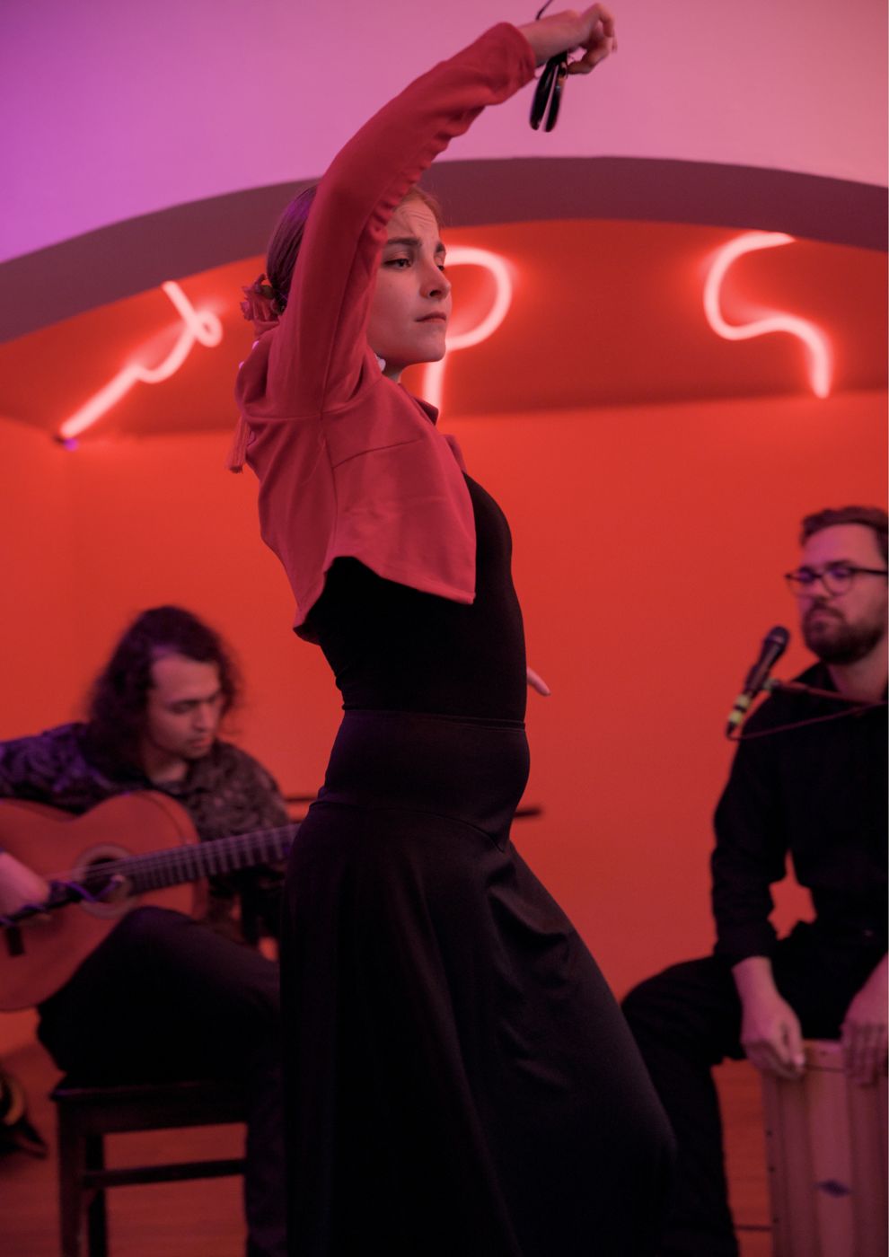 A dancer with castanets, guitar and cajón behind her