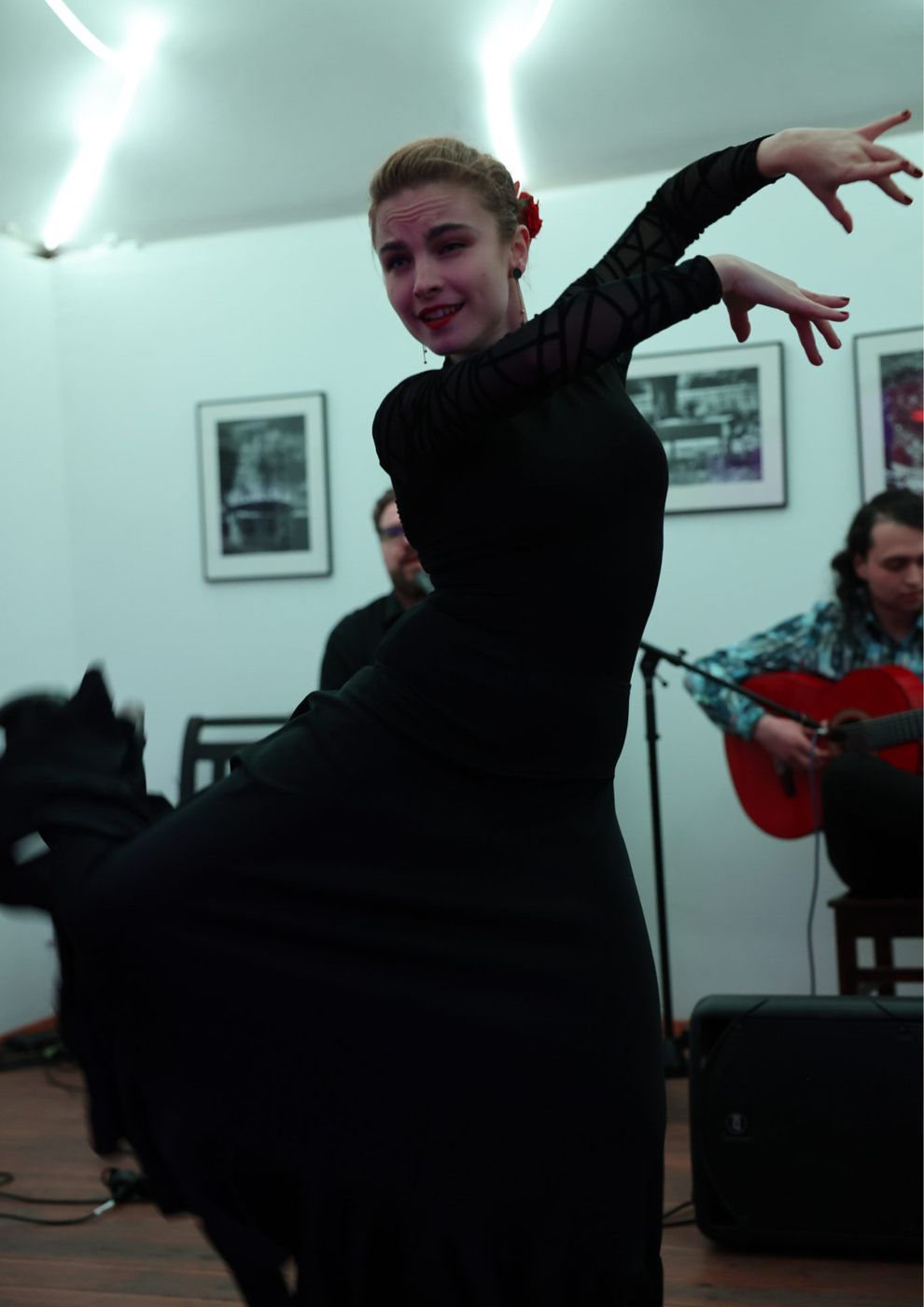 A dancer in black with the musicians behind her