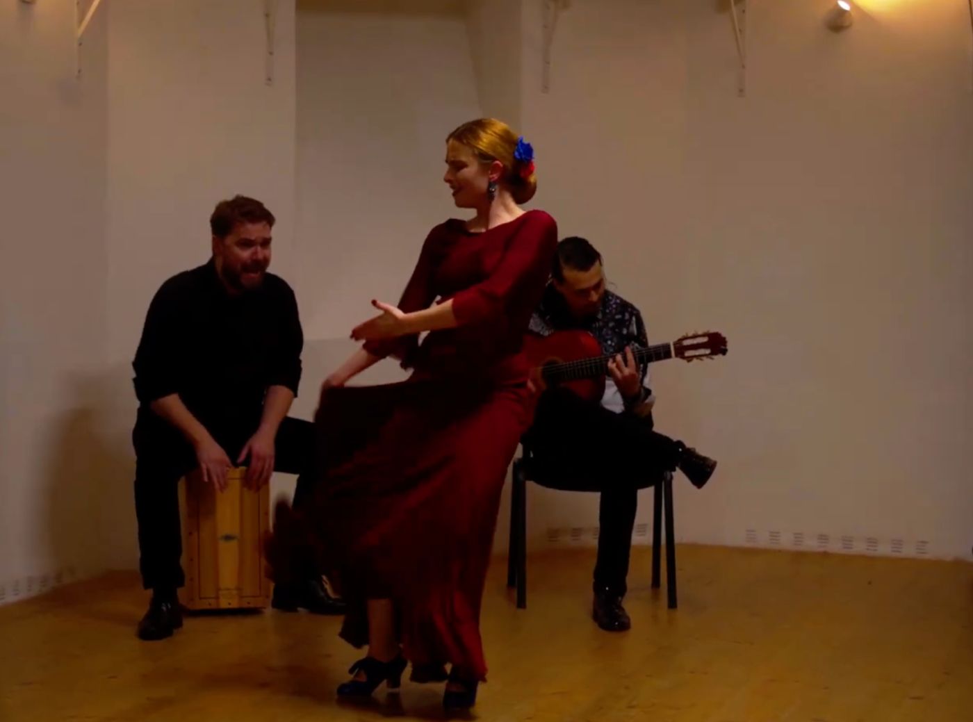 A dancer in a red dress with cajón and guitar