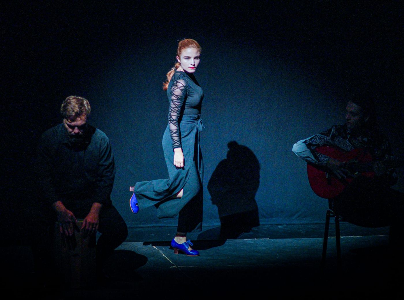 A dancer in a spotlight with the musicians